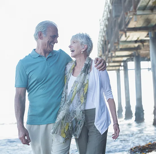 retired couple walking on the beach together retirement strategy